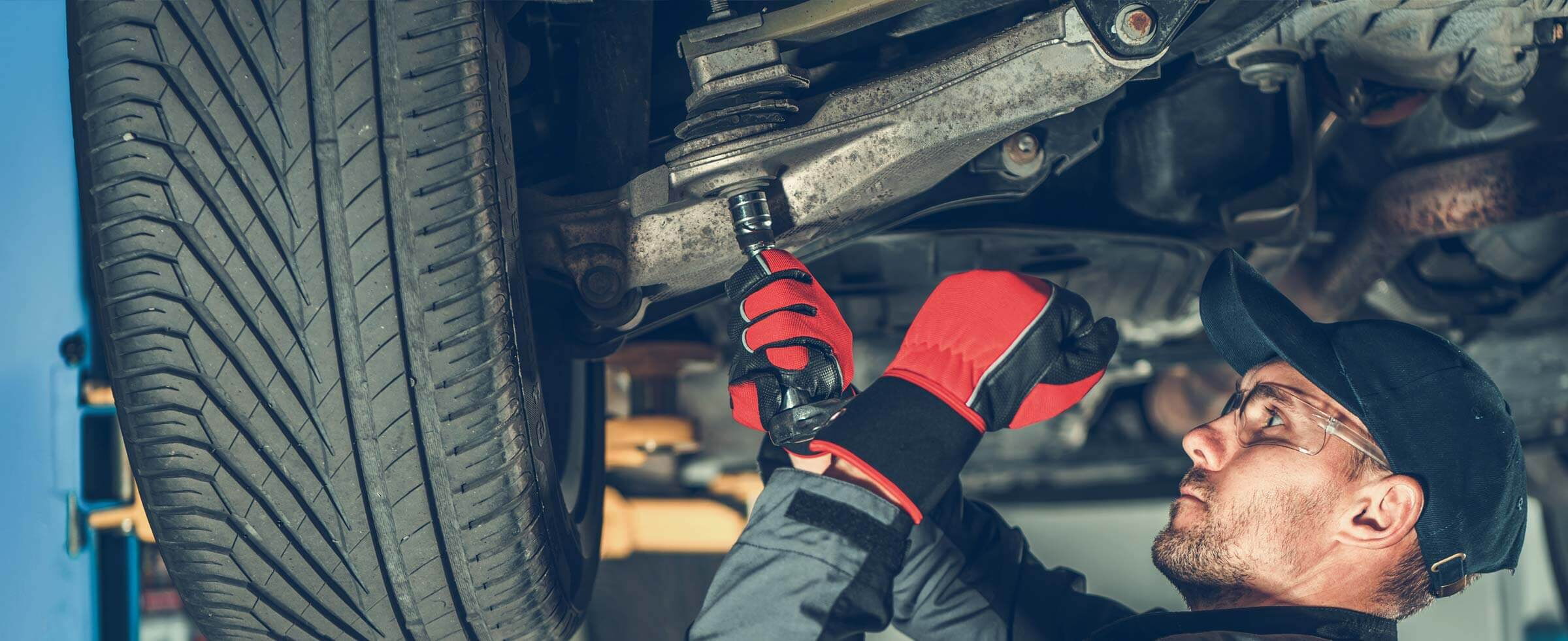 mechanic working under a car using Mayhew tool